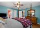 Spacious main bedroom features blue walls, wood flooring and adjacent bathroom at 4499 Collins Rd, Spring Hill, FL 34606