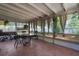 Enclosed patio featuring tile flooring, a glass-top table with chairs, and views of the lush yard at 4499 Collins Rd, Spring Hill, FL 34606