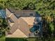 Aerial view highlighting the home's tile roof, screened-in pool, and lush surroundings, creating a private oasis at 4962 Turtle Creek Trl, Oldsmar, FL 34677