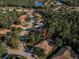 Aerial view showcases the neighborhood with mature trees, a serene lake, and well-maintained streets in a tranquil setting at 4962 Turtle Creek Trl, Oldsmar, FL 34677