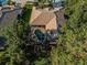 Aerial view of a private backyard with a screened pool, spa, and fire pit surrounded by mature trees at 4962 Turtle Creek Trl, Oldsmar, FL 34677
