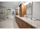 Bright bathroom features a modern vanity with stone countertops, soaking tub, and tiled walk-in shower at 4962 Turtle Creek Trl, Oldsmar, FL 34677