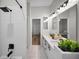 This bathroom has a stylish design with a white tiled wall, black hardware, and decorative plants at 4962 Turtle Creek Trl, Oldsmar, FL 34677