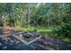 Inviting backyard fire pit with custom bench seating offers a cozy and relaxing outdoor gathering space at 4962 Turtle Creek Trl, Oldsmar, FL 34677
