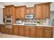 Custom kitchen features sleek stainless steel appliances, wood cabinets, and stylish backsplash at 4962 Turtle Creek Trl, Oldsmar, FL 34677