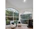 Spacious living room with tall stained glass windows, hardwood floors, a cozy fireplace, and modern furnishings at 4962 Turtle Creek Trl, Oldsmar, FL 34677