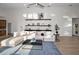 Inviting living room features stylish decor, including floating shelves, and seamlessly connects to an open kitchen at 4962 Turtle Creek Trl, Oldsmar, FL 34677