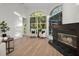 Sunlit living room features stained glass windows, a cozy fireplace, and modern furnishings on hardwood floors at 4962 Turtle Creek Trl, Oldsmar, FL 34677