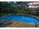Sparkling pool inside screened enclosure with tile trim, surrounded by lounge chairs and lush greenery for serene relaxation at 4962 Turtle Creek Trl, Oldsmar, FL 34677