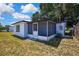 Back exterior of the home, featuring an enclosed patio and well-maintained lawn at 5053 Lofton Dr, New Port Richey, FL 34652