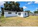 The backyard features a grassy lawn and the exterior of the home at 5053 Lofton Dr, New Port Richey, FL 34652