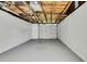 Open basement space has a garage door and bare ceiling at 5053 Lofton Dr, New Port Richey, FL 34652