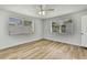 Bedroom with light wood flooring, a ceiling fan, and natural light from two windows at 5053 Lofton Dr, New Port Richey, FL 34652
