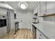 Modern kitchen featuring stainless steel appliances, light wood floors, and crisp white cabinetry at 5053 Lofton Dr, New Port Richey, FL 34652