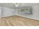 Bright living room featuring a ceiling fan, large window, and durable light wood flooring at 5053 Lofton Dr, New Port Richey, FL 34652