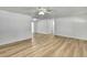 Spacious living room featuring light wood flooring, a ceiling fan, and white walls at 5053 Lofton Dr, New Port Richey, FL 34652