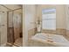 Bathroom showcasing a soaking tub, a separate walk-in shower, and elegant neutral-toned tiling at 510 33Rd N Ave, St Petersburg, FL 33704