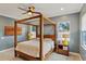Well-lit bedroom with a wooden four-poster bed, bedside tables, ceiling fan and soft, blue walls at 510 33Rd N Ave, St Petersburg, FL 33704