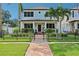Charming two-story home with manicured lawn, mature palms, and a decorative fence at 510 33Rd N Ave, St Petersburg, FL 33704