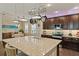 Granite island with sink and stainless steel appliances in an open kitchen with dark wood cabinets at 510 33Rd N Ave, St Petersburg, FL 33704