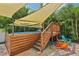 Pool featuring a wooden deck, shade sail, and outdoor seating surrounded by lush greenery at 510 33Rd N Ave, St Petersburg, FL 33704