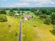 Sprawling green property showcases a long driveway leading to the charming home and outbuildings at 5100 Lockhart Rd, Brooksville, FL 34602