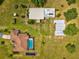 Aerial view showcases a home with a pool and multiple outbuildings on a large lot at 5100 Lockhart Rd, Brooksville, FL 34602