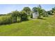 Lush backyard featuring a small shed and vibrant shrubbery at 5100 Lockhart Rd, Brooksville, FL 34602