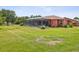 Spacious backyard with a screened-in pool area, mature landscaping, and ample space for outdoor activities at 5100 Lockhart Rd, Brooksville, FL 34602