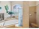 Shower and bathtub area featuring tiled walls, neutral colors, and a privacy glass divider panel at 5100 Lockhart Rd, Brooksville, FL 34602