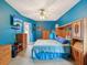 Blue main bedroom with matching bedding, a ceiling fan, and wood furnishings at 5100 Lockhart Rd, Brooksville, FL 34602