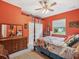 Cozy bedroom with orange walls, wood furniture and a floral comforter at 5100 Lockhart Rd, Brooksville, FL 34602
