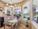 Bright breakfast nook with tiled table and three windows, offering a view of the backyard and pool at 5100 Lockhart Rd, Brooksville, FL 34602