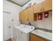 Laundry room featuring washer and dryer, utility sink, and overhead cabinet storage at 5100 Lockhart Rd, Brooksville, FL 34602