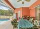 Outdoor patio with dining table, ceiling fan, tropical plants, and access to the screened-in pool area at 5100 Lockhart Rd, Brooksville, FL 34602