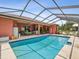 A beautiful view of the screened-in pool with comfortable patio furniture and an outdoor grill at 5100 Lockhart Rd, Brooksville, FL 34602