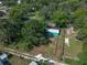 Aerial view of a charming green home with a fenced yard shaded by mature trees at 5510 12Th St, Zephyrhills, FL 33542