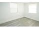 Clean bedroom featuring neutral walls, wood-look flooring, and two windows for natural light at 5510 12Th St, Zephyrhills, FL 33542