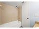 Bright bathroom features a tub and shower with neutral-colored tiling at 6324 Newtown Cir # 24B1, Tampa, FL 33615
