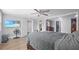Comfortable bedroom featuring hardwood floors, a ceiling fan, and a glimpse into the walk-in closet and bathroom at 6334 Hyperion Dr, Port Richey, FL 34668