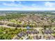 Drone shot of a residential neighborhood near a highway, featuring a mix of townhomes and green spaces at 6974 Holly Heath Dr, Riverview, FL 33578
