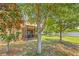 View of the backyard with a screened lanai, green grass and mature trees offering pleasant shade at 6974 Holly Heath Dr, Riverview, FL 33578