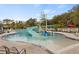 Beautiful community pool featuring a water slide and splash bucket surrounded by lounge chairs and lush landscaping at 6974 Holly Heath Dr, Riverview, FL 33578