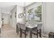 A dining room features a dark wood table, four gray chairs, a window, and an overhead light fixture at 6974 Holly Heath Dr, Riverview, FL 33578