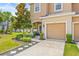Lovely townhome boasts a beautifully landscaped yard, inviting entryway, and attached two-car garage at 6974 Holly Heath Dr, Riverview, FL 33578