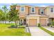 Charming townhome featuring a two-car garage, landscaped front yard, and a welcoming covered entryway at 6974 Holly Heath Dr, Riverview, FL 33578