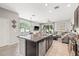 A kitchen with a granite island and stainless steel appliances open to dining and living areas at 6974 Holly Heath Dr, Riverview, FL 33578