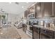 A kitchen with granite counters, tiled backsplash, stainless steel appliances, and dark wood cabinets at 6974 Holly Heath Dr, Riverview, FL 33578