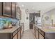 A kitchen featuring granite counters, tiled backsplash, stainless steel appliances, and dark wood cabinets at 6974 Holly Heath Dr, Riverview, FL 33578