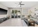 A living room with tile floors, large windows, a ceiling fan, and contemporary furniture at 6974 Holly Heath Dr, Riverview, FL 33578